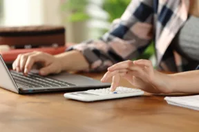 una persona al pc con la calcolatrice