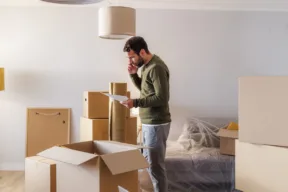 uomo in stanza con scatoloni