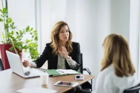 due persone parlano alla scrivania