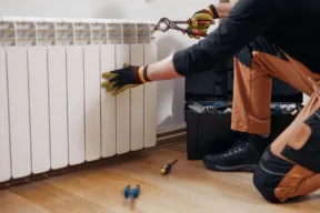 tecnico aggiusta un termosifone
