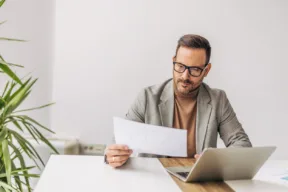 una persona al pc con un documento
