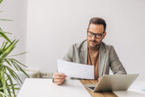 una persona al pc con un documento