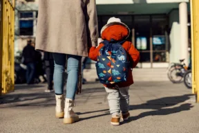 una persona accompagna un bambino all'asilo