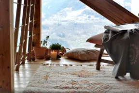 tappeto, cuscino e sedia in una stanza in montagna