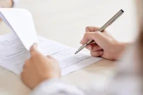 una persona firma un documento