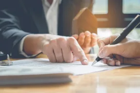 un persona firma un documento