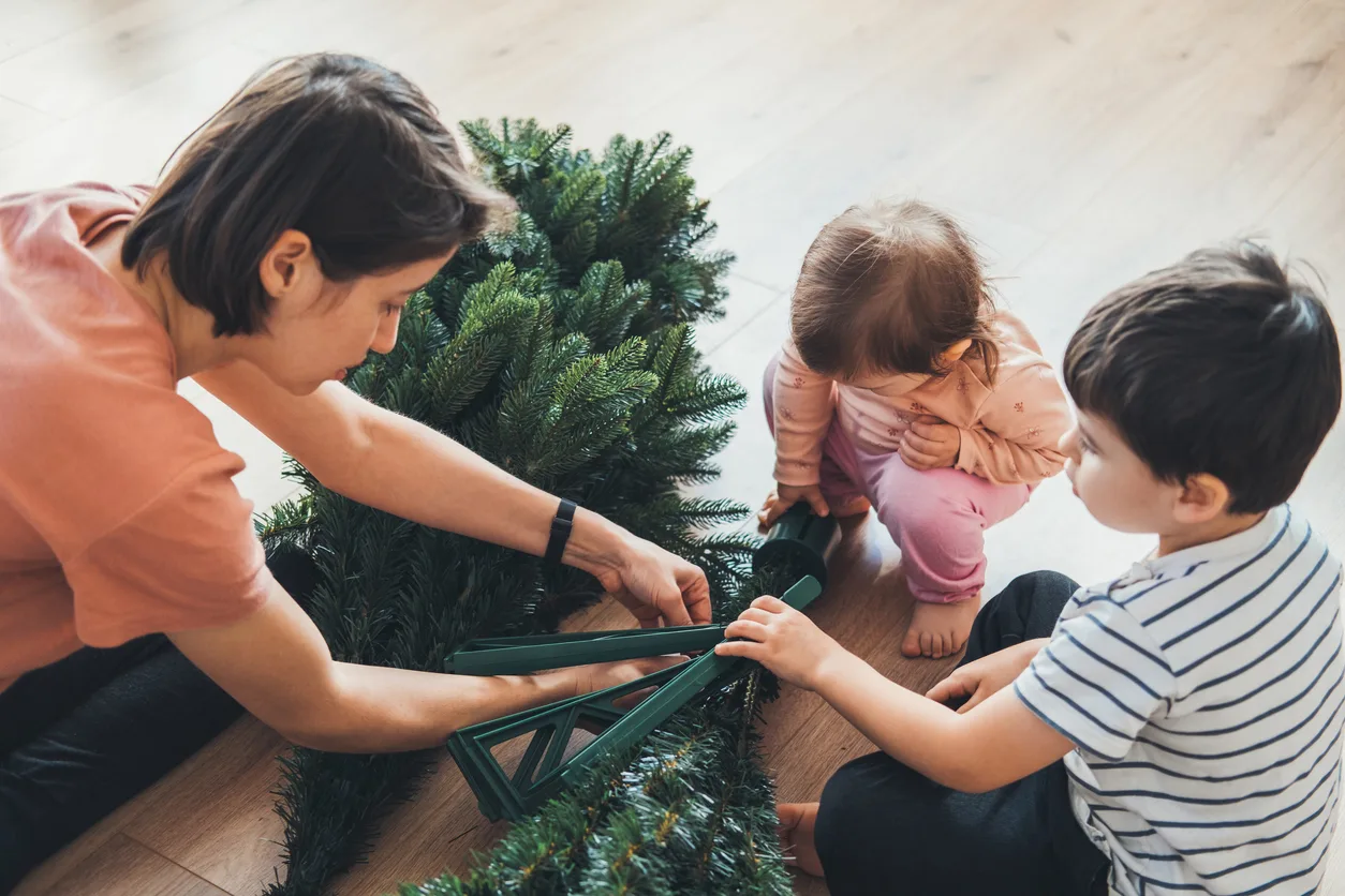 Famiglia che smonta un albero di Natale sintetico