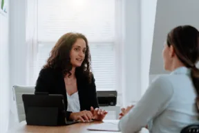 due persone parlano alla scrivania