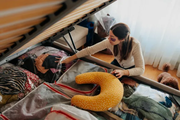 una persona organizza lo spazio nel letto contenitore