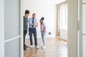 agente immobiliare fa vedere casa a due persone