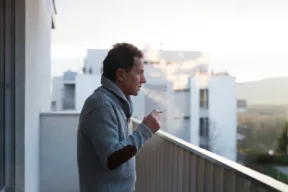 una persona fuma sul balcone