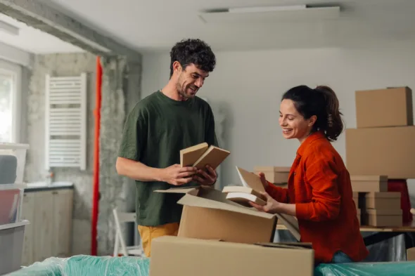 due persone mettono i libri nelle scatole