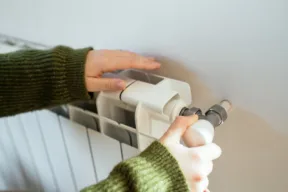 mani di giovane ragazza su termosifone