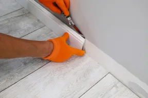 persona sostituisce il battiscopa