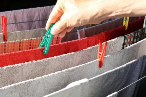 mano mette mollette a panni su stendibiancheria