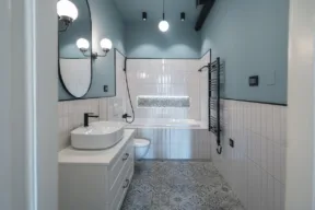 bagno moderno con piastrelle bianche a metà muro e parete azzurra