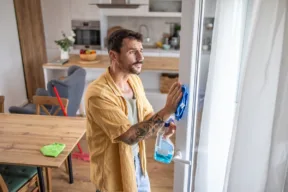 persona pulisce telaio bianco della finestra