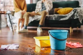 secchi e ciotole in salotto in cui piove dentro