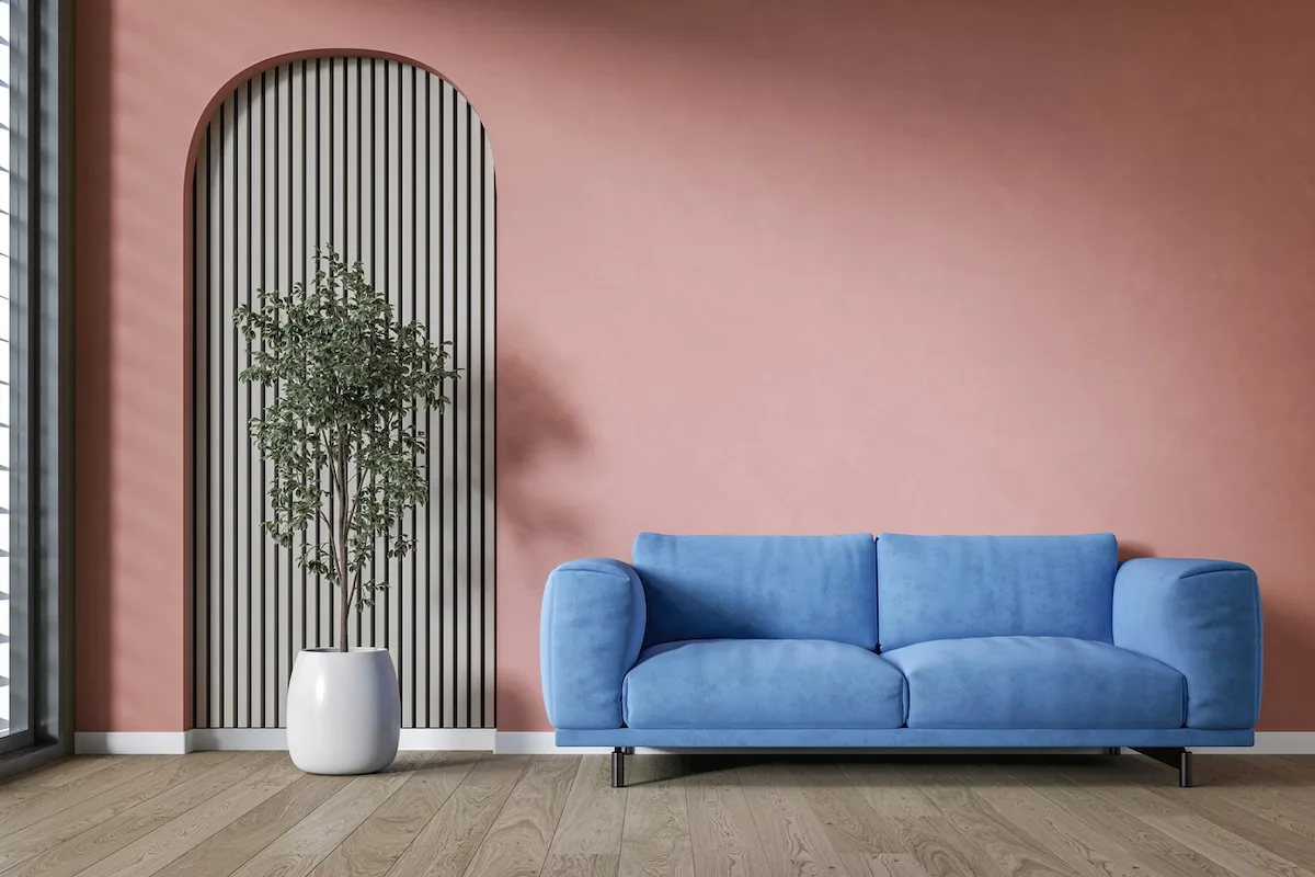 soggiorno con parete corallo e divano blu navy