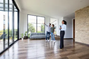 due persone visitano una casa con l'agente immobiliare