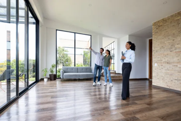 due persone visitano una casa con l'agente immobiliare