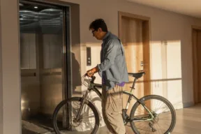 signore entra in ascensore con la bicicletta