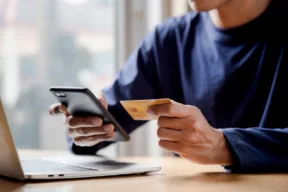 una persona con telefono e carta di credito