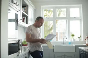 una persona legge un documento in cucina