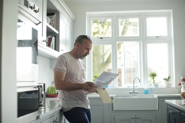 una persona legge un documento in cucina
