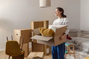 donna porta scatolone in casa nuova