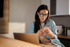 una persona usa il telefono mentre è al computer