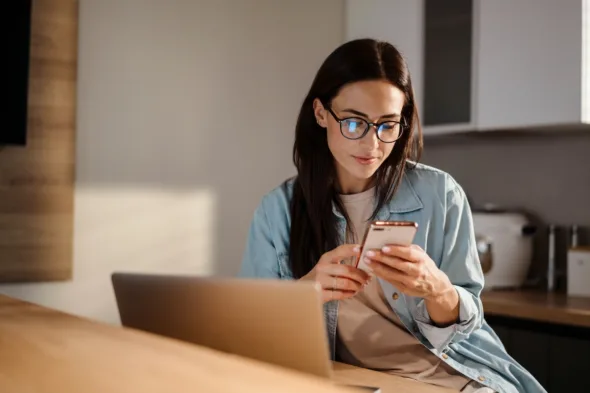 una persona usa il telefono mentre è al computer
