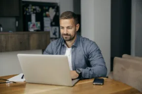 uomo lavora al computer dal salotto