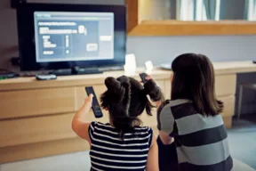 due persone cercano di sistemare la televisione dal menù impostazioni