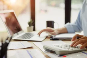 uomo fa i conti davanti al computer