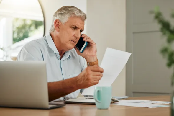 una persona a telefono controlla un documento