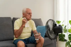 uomo accaldato davanti a ventilatore