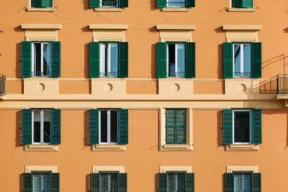 facciata condominio arancione con persiane verdi