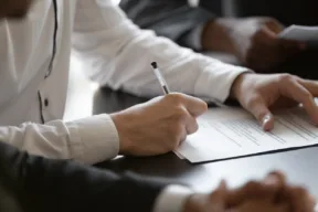 una persona firma un contratto