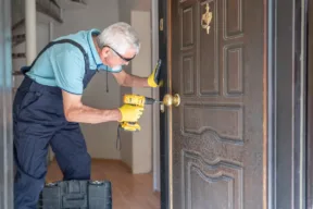 signore cambia la serratura di una casa